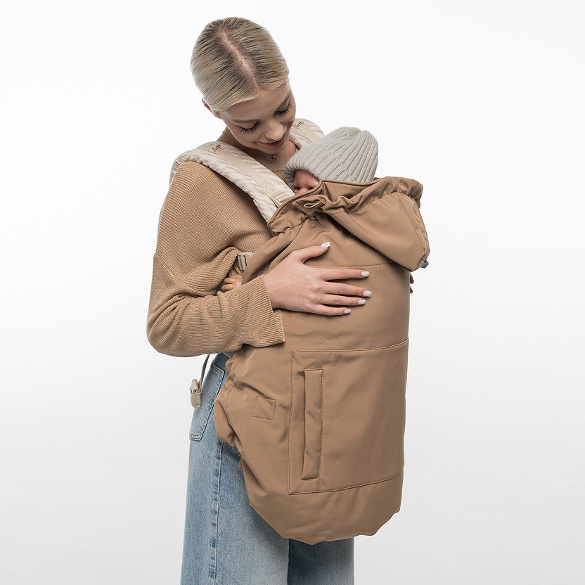 Brown Love&Carry Softshell multi-season babywearing cover attached to an ergonomic carrier.